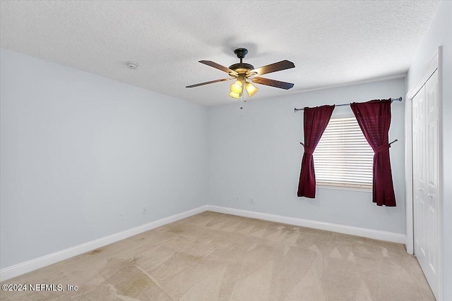 carpeted empty room with a textured ceiling and ceiling fan