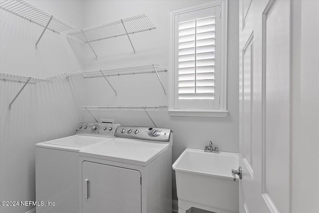 laundry area featuring a wealth of natural light, sink, and washing machine and clothes dryer