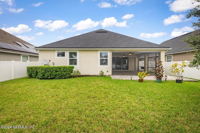 back of property featuring ceiling fan, a patio area, and a yard