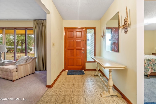 carpeted entryway with a textured ceiling