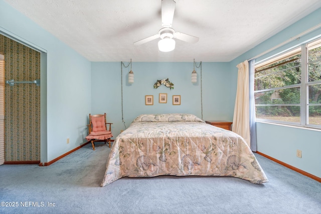 bedroom with ceiling fan, carpet, and a textured ceiling