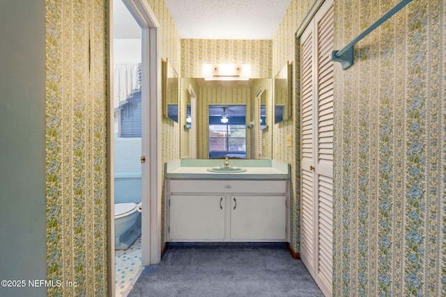 bathroom featuring vanity, toilet, and a textured ceiling