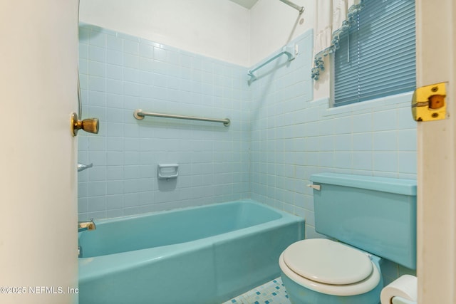 bathroom with toilet and tiled shower / bath