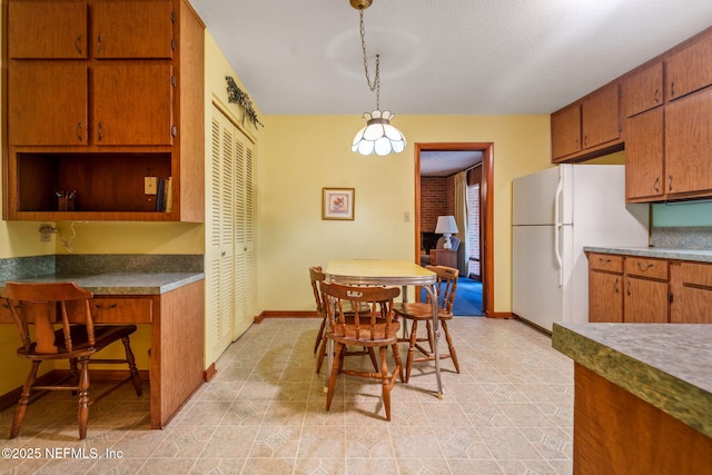 kitchen with hanging light fixtures, a textured ceiling, and white fridge