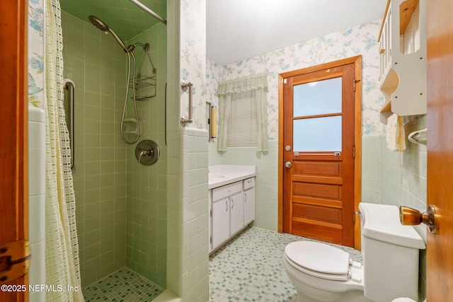 bathroom with tiled shower, vanity, and toilet