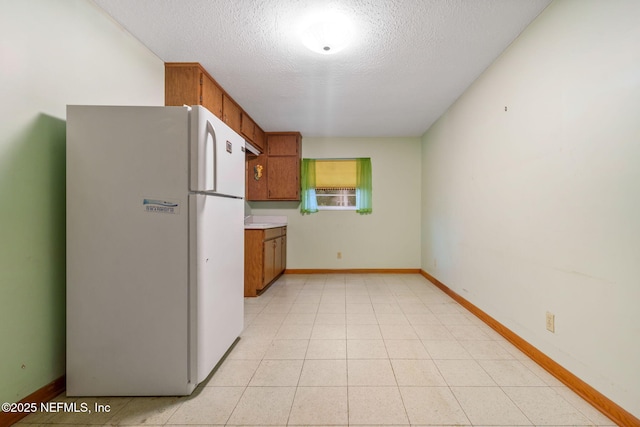 kitchen with white fridge and a textured ceiling