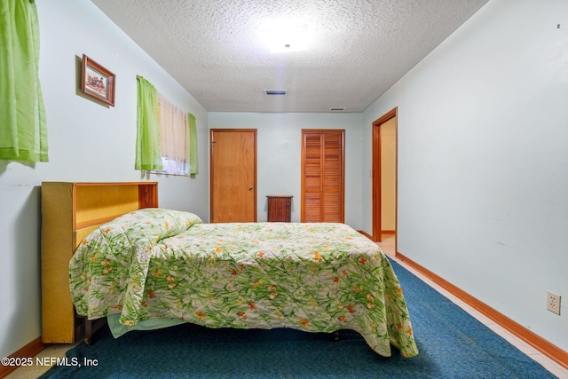 bedroom featuring carpet flooring and a textured ceiling