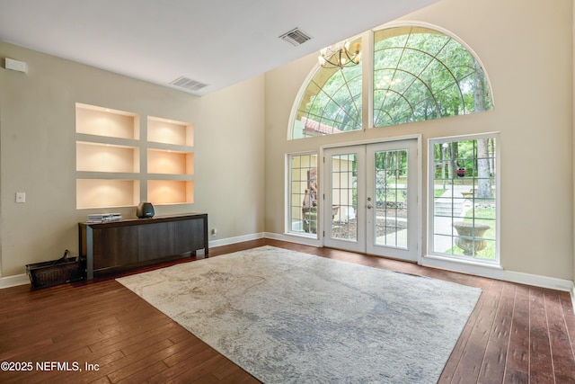 doorway to outside featuring dark hardwood / wood-style floors, french doors, a chandelier, and a high ceiling