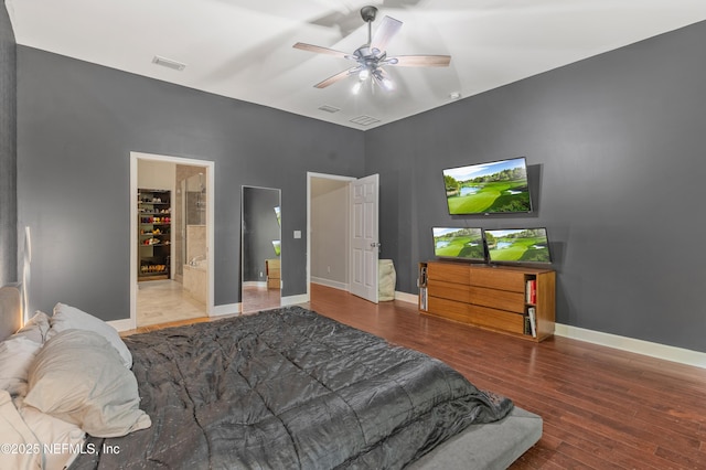 bedroom with hardwood / wood-style flooring, connected bathroom, and ceiling fan