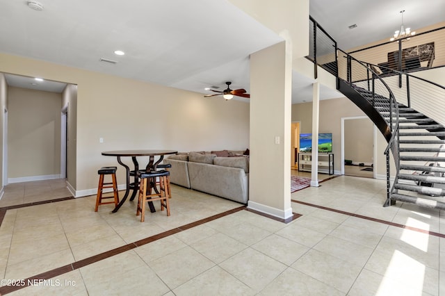 tiled living room featuring ceiling fan with notable chandelier