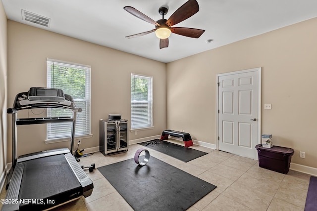 exercise area featuring light tile patterned flooring and ceiling fan