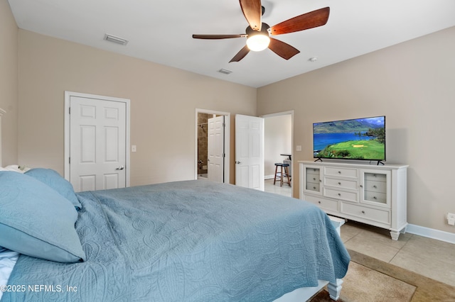 tiled bedroom with ensuite bath and ceiling fan