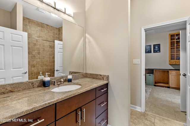 bathroom with tile patterned flooring, vanity, tile walls, and walk in shower