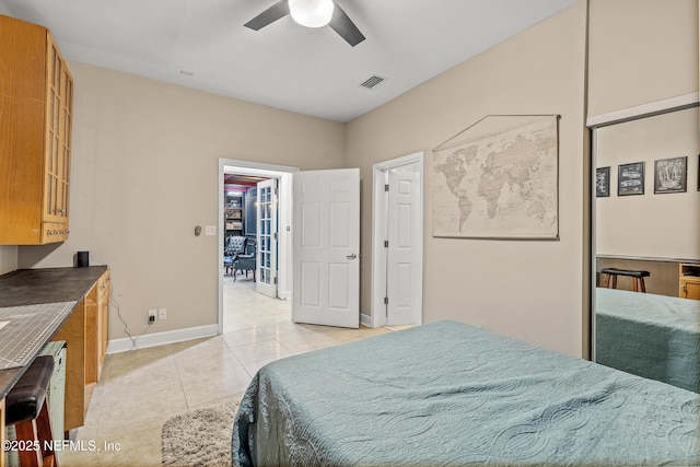 bedroom featuring light tile patterned floors, a spacious closet, a closet, and ceiling fan