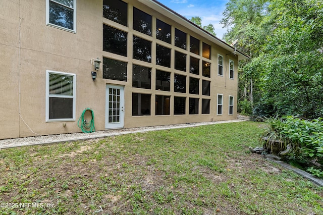 rear view of house featuring a lawn