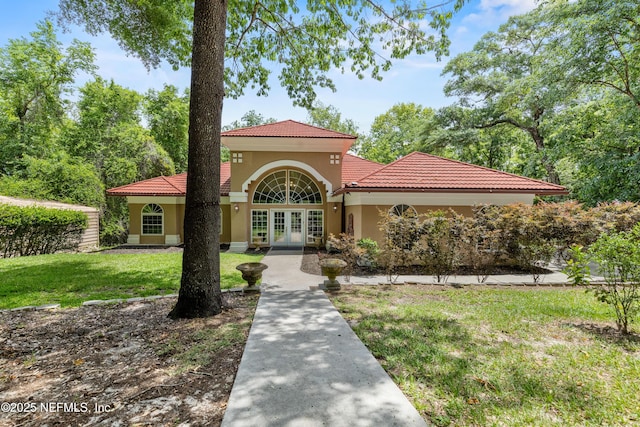 mediterranean / spanish-style home with french doors and a front lawn