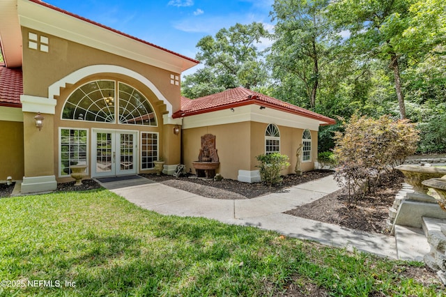 rear view of property featuring a yard and french doors