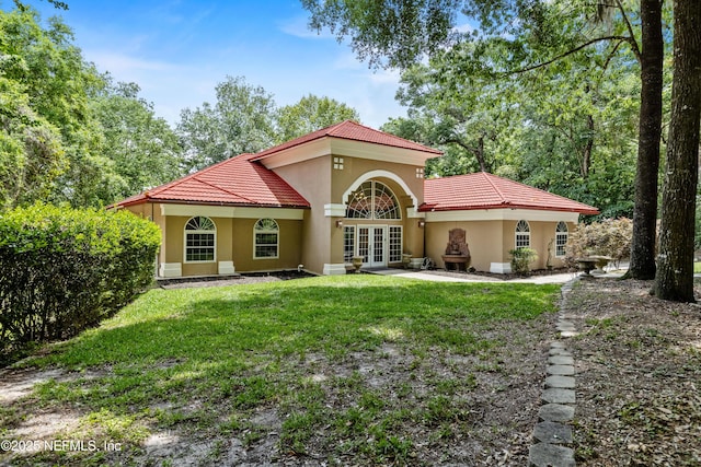 back of house with a lawn and french doors