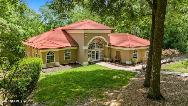 back of house featuring a yard and french doors