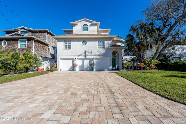 view of front of home with a garage and a front lawn