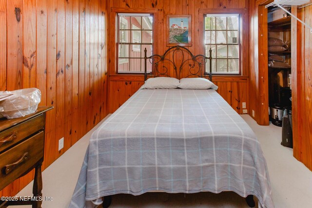 bedroom featuring wooden walls