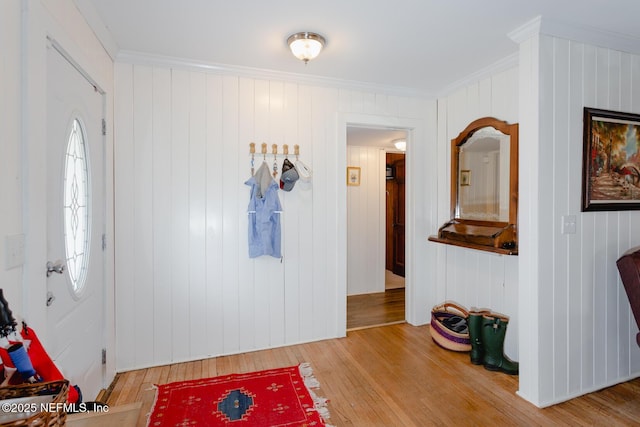 entryway with hardwood / wood-style floors, crown molding, and wooden walls