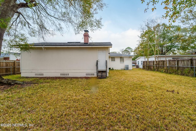 rear view of property featuring a yard and cooling unit