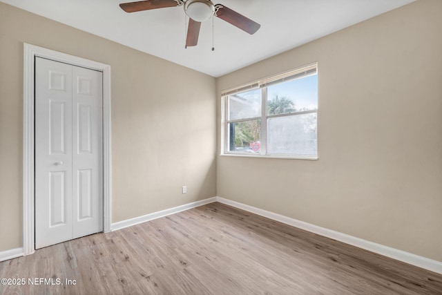 unfurnished bedroom featuring a closet, ceiling fan, and light wood-type flooring