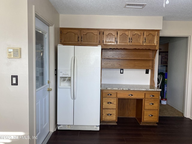 kitchen with white refrigerator with ice dispenser, light stone countertops, dark hardwood / wood-style floors, and a textured ceiling