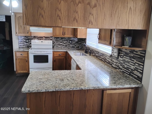 kitchen featuring dark wood-type flooring, sink, light stone counters, kitchen peninsula, and white appliances