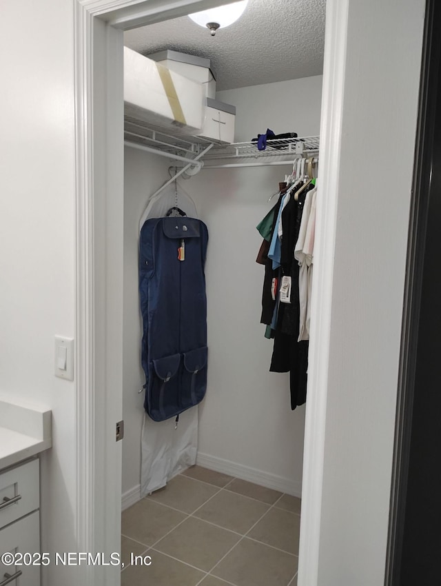 spacious closet with light tile patterned floors