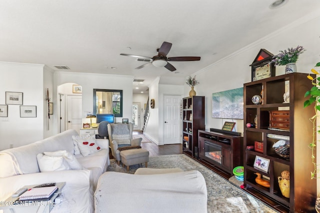 living room with hardwood / wood-style flooring, ceiling fan, and crown molding