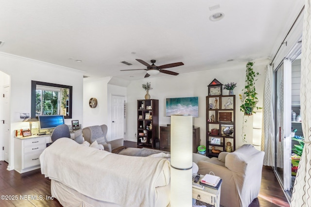 living room with dark hardwood / wood-style flooring, crown molding, and ceiling fan