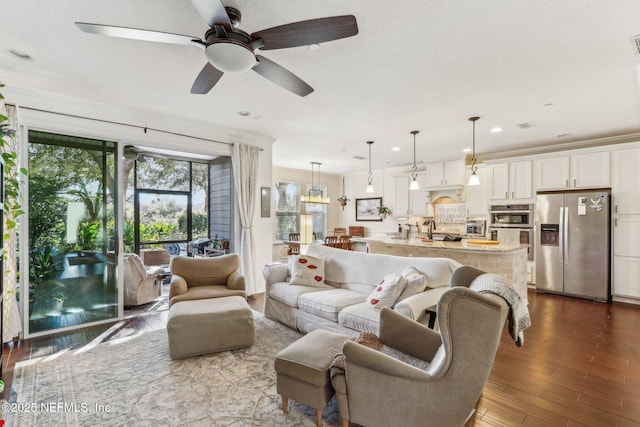 living room featuring dark hardwood / wood-style floors, sink, and ceiling fan