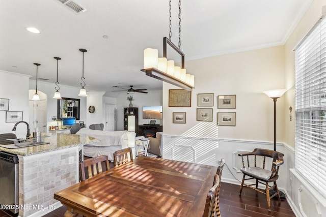 dining room with a healthy amount of sunlight, ornamental molding, dark hardwood / wood-style flooring, and sink