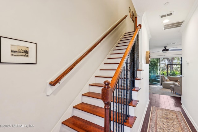 staircase featuring wood-type flooring and ceiling fan