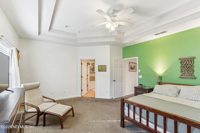 bedroom with ceiling fan, light colored carpet, and a raised ceiling