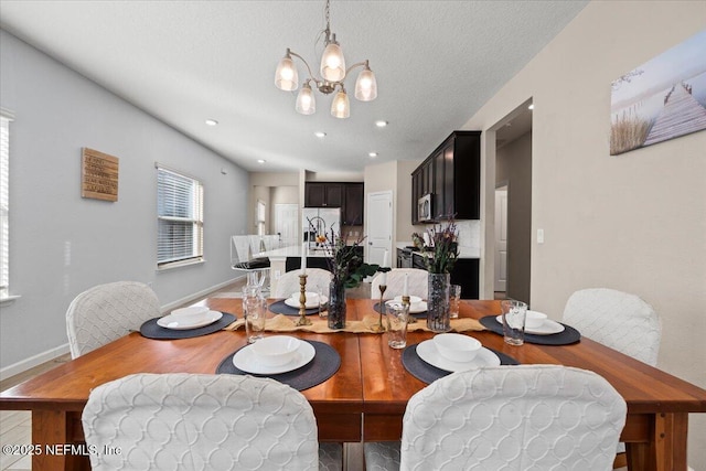 dining space with a textured ceiling and a chandelier