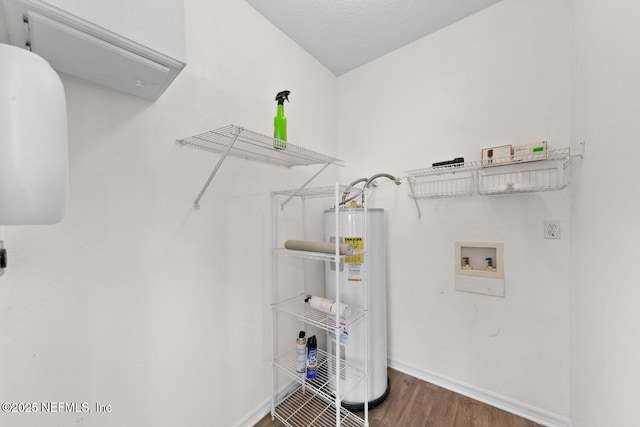 washroom with washer hookup, hardwood / wood-style flooring, water heater, and a textured ceiling