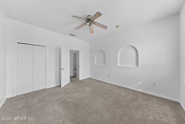 unfurnished bedroom featuring a closet, ceiling fan, and carpet