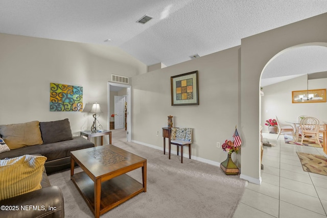 living room with light tile patterned floors, a chandelier, and lofted ceiling