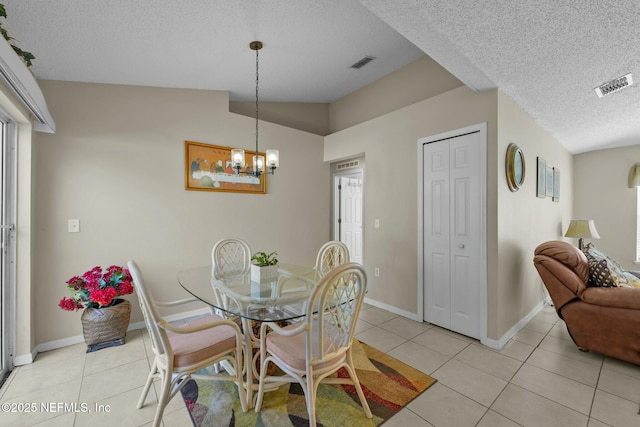 dining space with a textured ceiling, light tile patterned flooring, lofted ceiling, and a chandelier