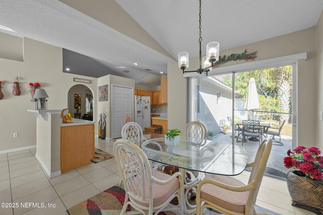 tiled dining space featuring lofted ceiling, a notable chandelier, and a textured ceiling