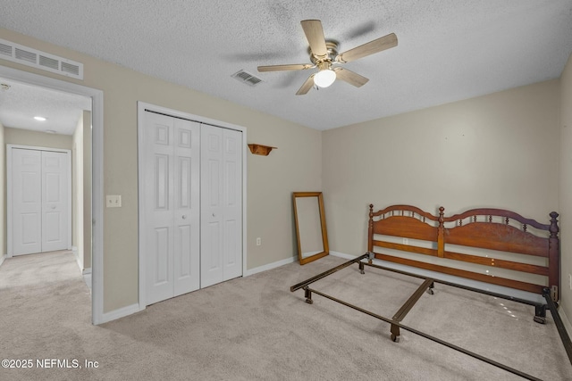 carpeted bedroom featuring ceiling fan, a closet, and a textured ceiling