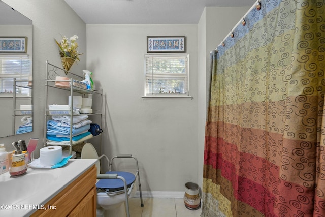 bathroom with toilet, vanity, and tile patterned flooring