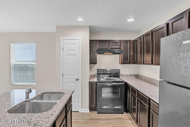 kitchen featuring sink, stainless steel refrigerator, light hardwood / wood-style flooring, light stone countertops, and black range with electric cooktop