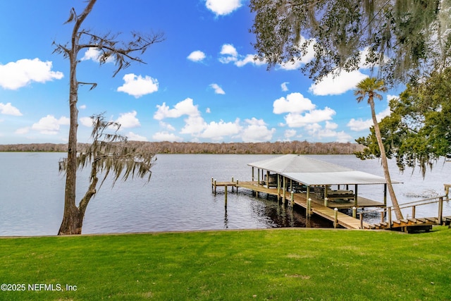 view of dock featuring a water view and a yard