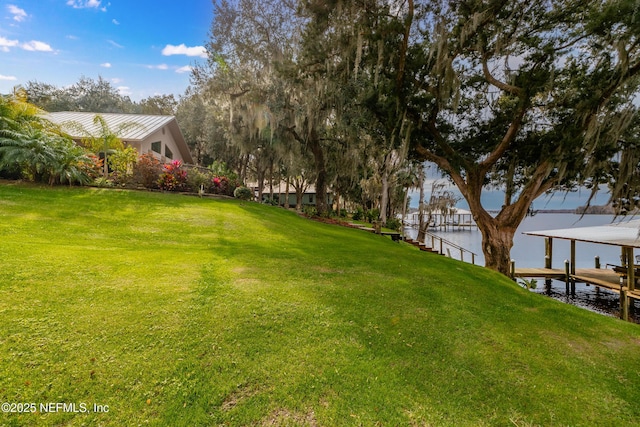 view of yard with a boat dock and a water view