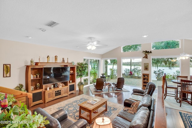 living room with ceiling fan, a textured ceiling, and hardwood / wood-style flooring