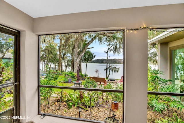 sunroom / solarium featuring a water view and plenty of natural light